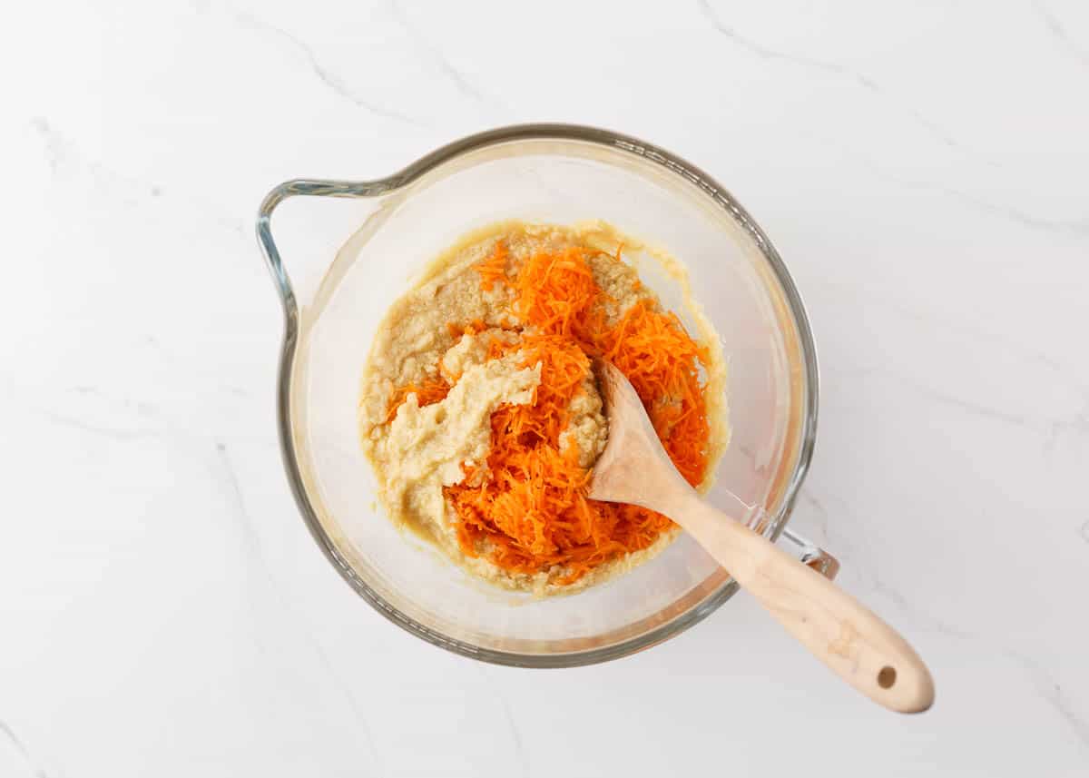 Creamed butter, sugars, eggs, carrots and vanilla in bowl.