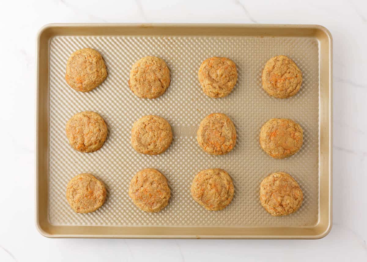 Baked carrot cake cookies on baking pan.