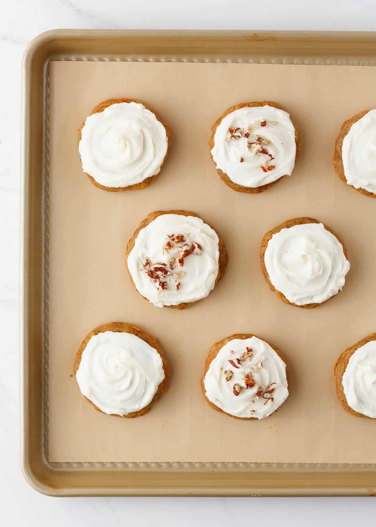 Frosted carrot cake cookies with cream cheese icing n baking pan.