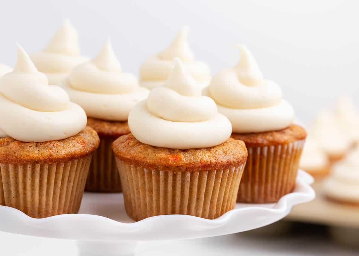 Carrot cupcakes on a cake dish. 