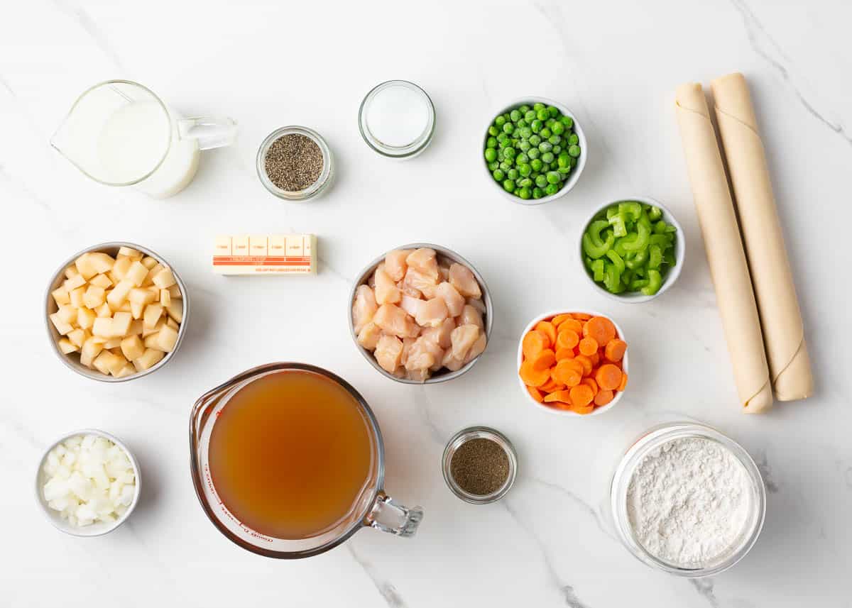 Chicken pot pie ingredients on marble counter.