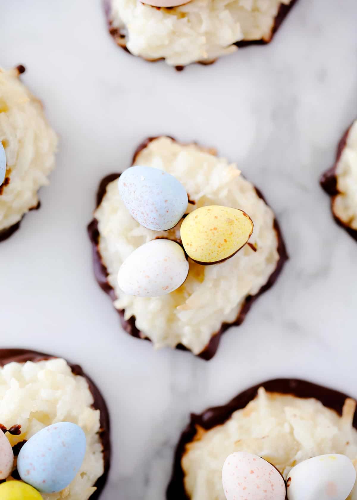 Easy coconut macaroons that are soft, chewy and full of coconut flavor. So simple to make...you only need 6 ingredients and one bowl! You can make them plain or dip them in chocolate for an added touch. Coconut macaroon with cadbury eggs on top.