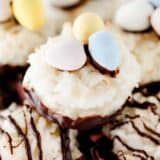 Coconut macaroons decorated like nests with Candy coat eggs on top.