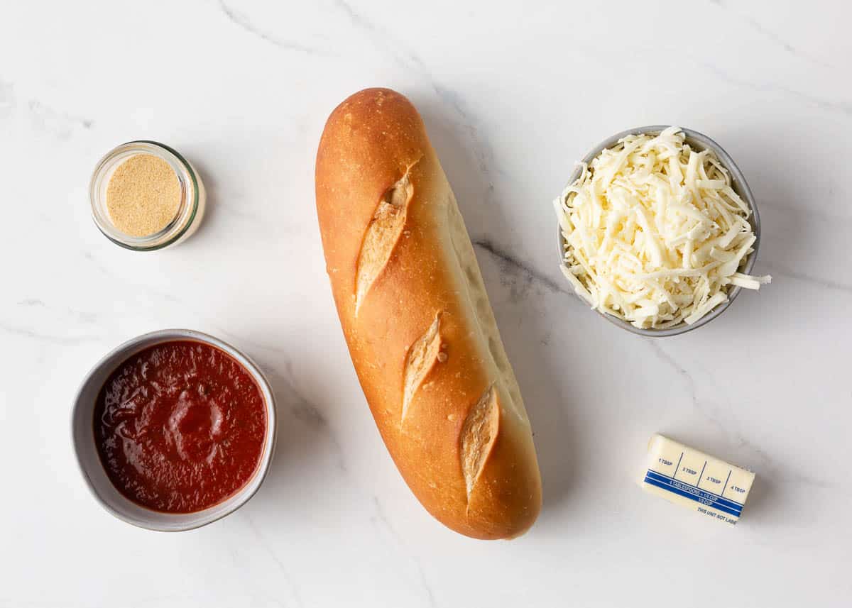 French bread pizza ingredients on counter.