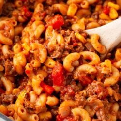 Goulash in a white pot with wooden spoon.