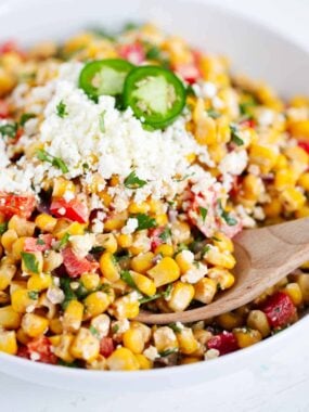Close up of Mexican street corn salad made with fire roasted corn and topped with cotija cheese and jalapeno.