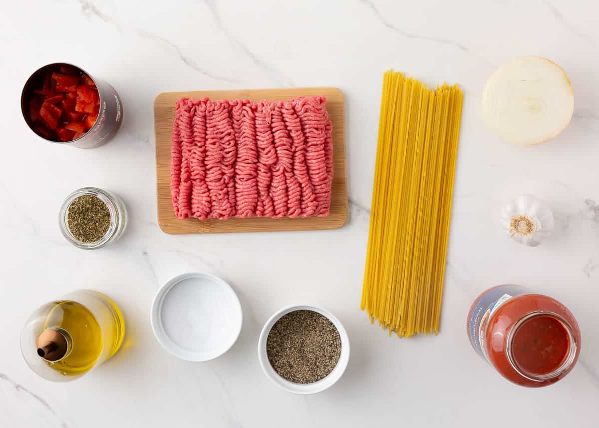 Spaghetti ingredients on marble counter.