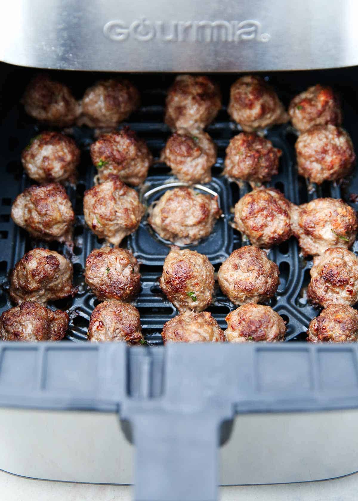 Meatballs in the air fryer basket.