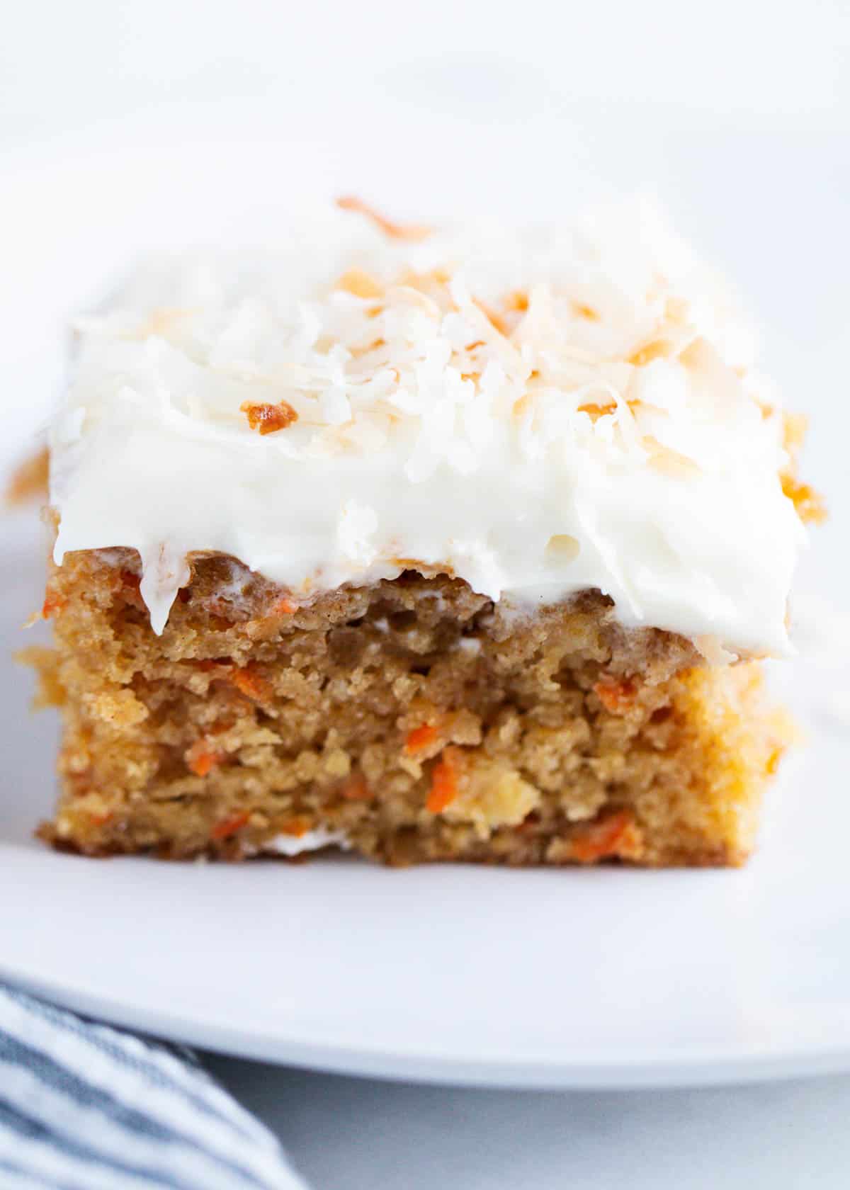 A slice of carrot cake with coconut on top. 