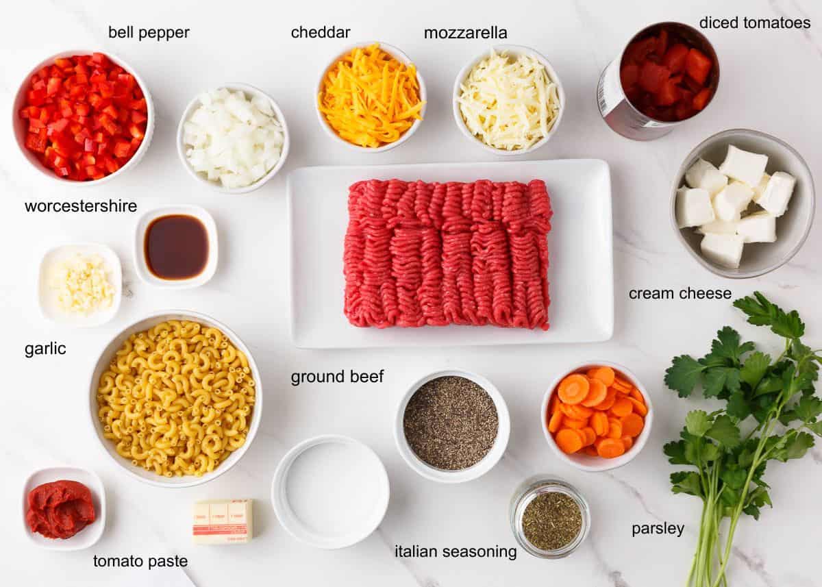 Easy, budget-friendly, and ready in under 1 hour! This easy hamburger casserole recipe has layers of saucy beef, tender noodles, and oodles of melted cheese then baked until bubbly. It's so good it's been on the menu at least once a month lately! Hamburger casserole ingredients including ground beef, elbow macaroni, bell pepper, onion, diced tomatoes, cream cheese, cheddar, mozzarella and seasonings.