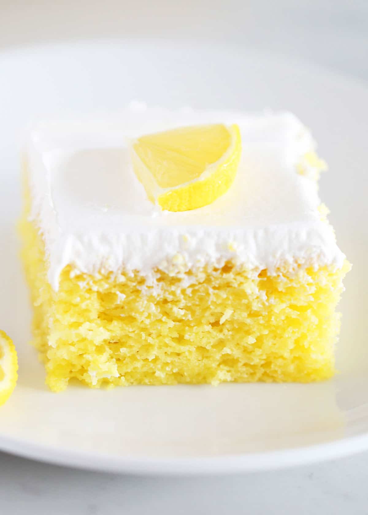 Lemon poke cake with a slice of lemon on top. 