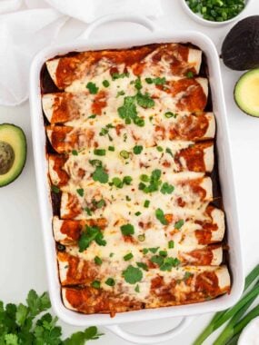 Beef enchiladas with cilantro on a white countertop.