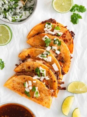 Birria tacos on a piece of parchment paper.