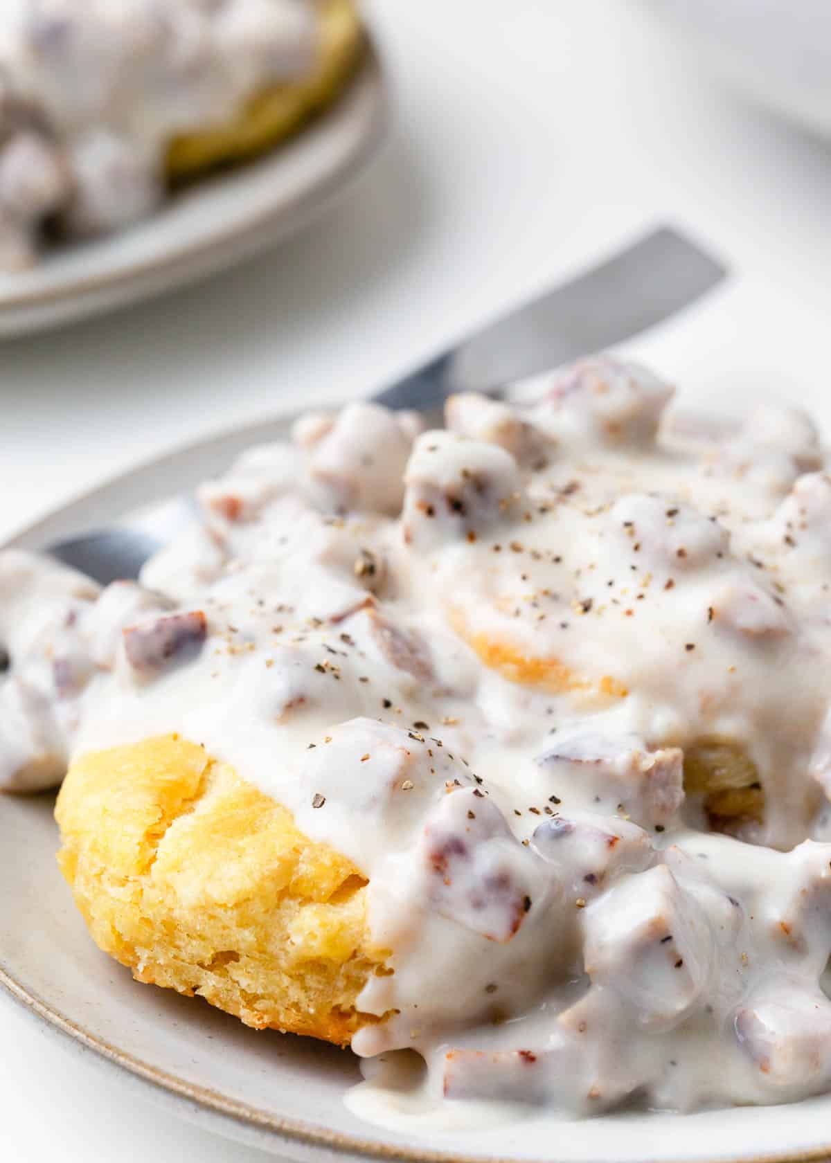 Biscuits and gravy on a plate with a fork.