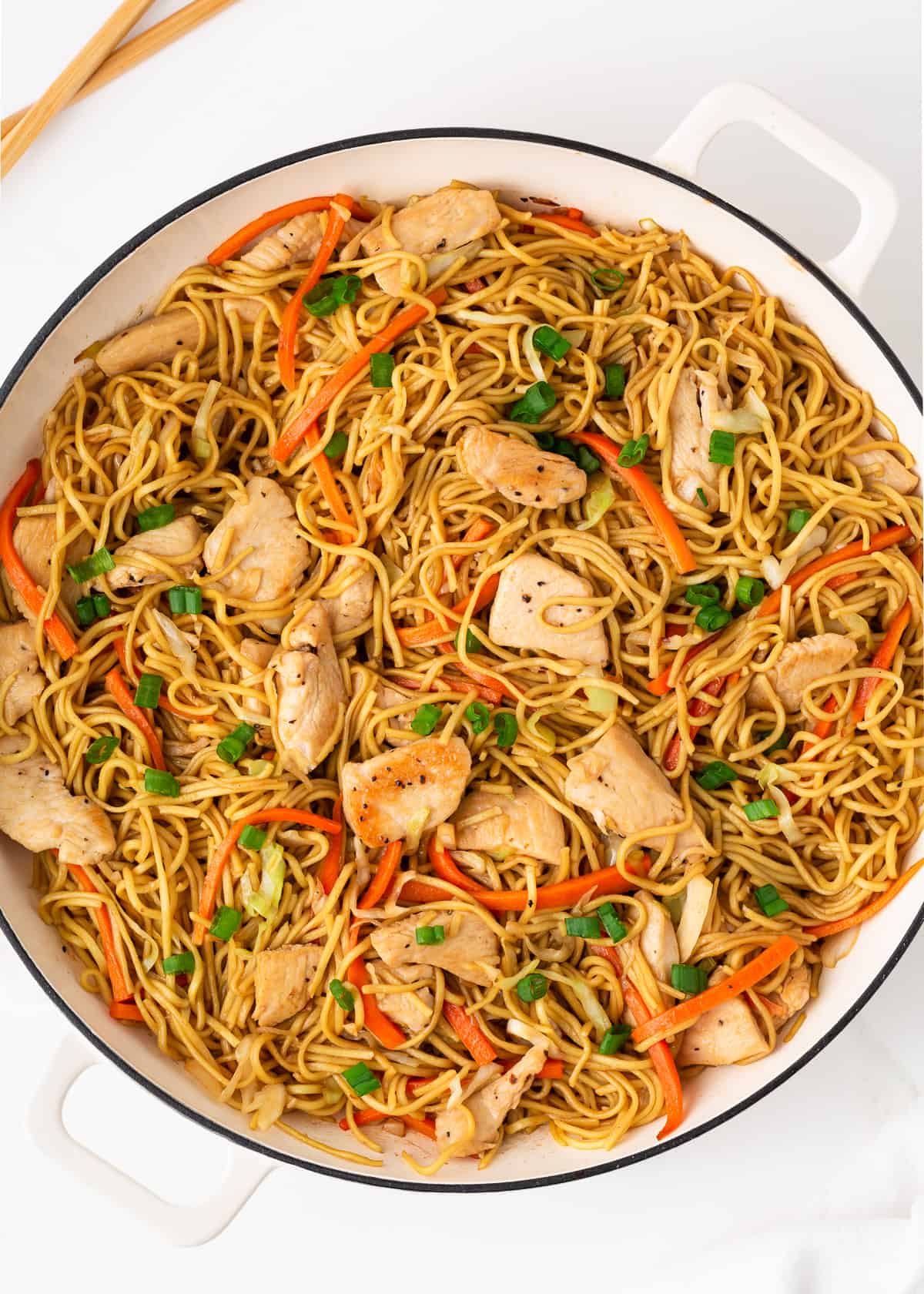 Chicken chow mein in a white skillet. 