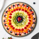 Fruit pizza on marble counter.