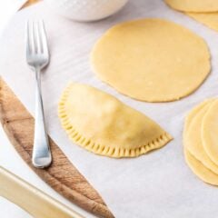 Making empanada dough on wooden board.