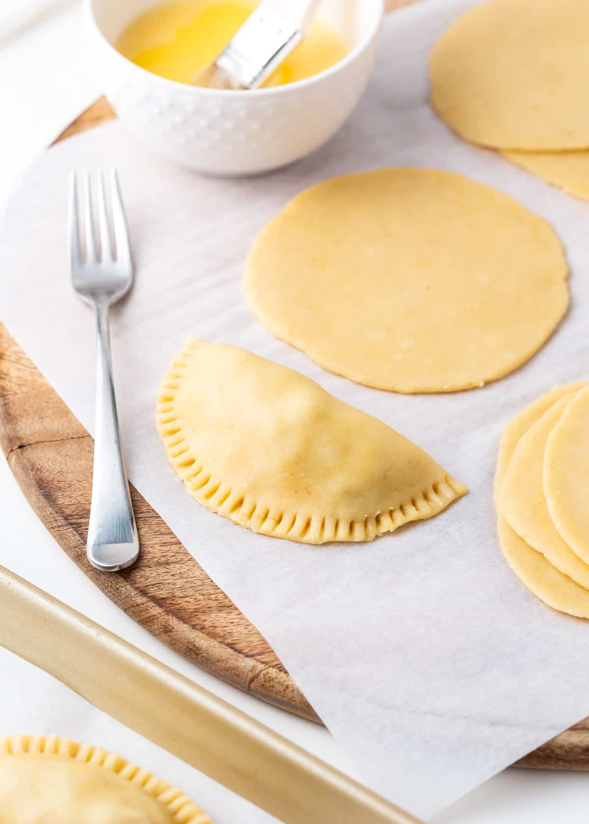 Making empanada dough on wooden board.