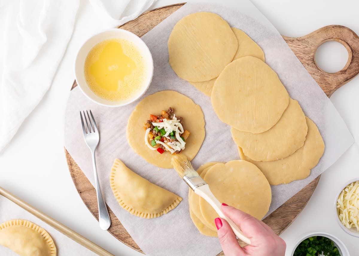 Putting filling in empanada dough. 