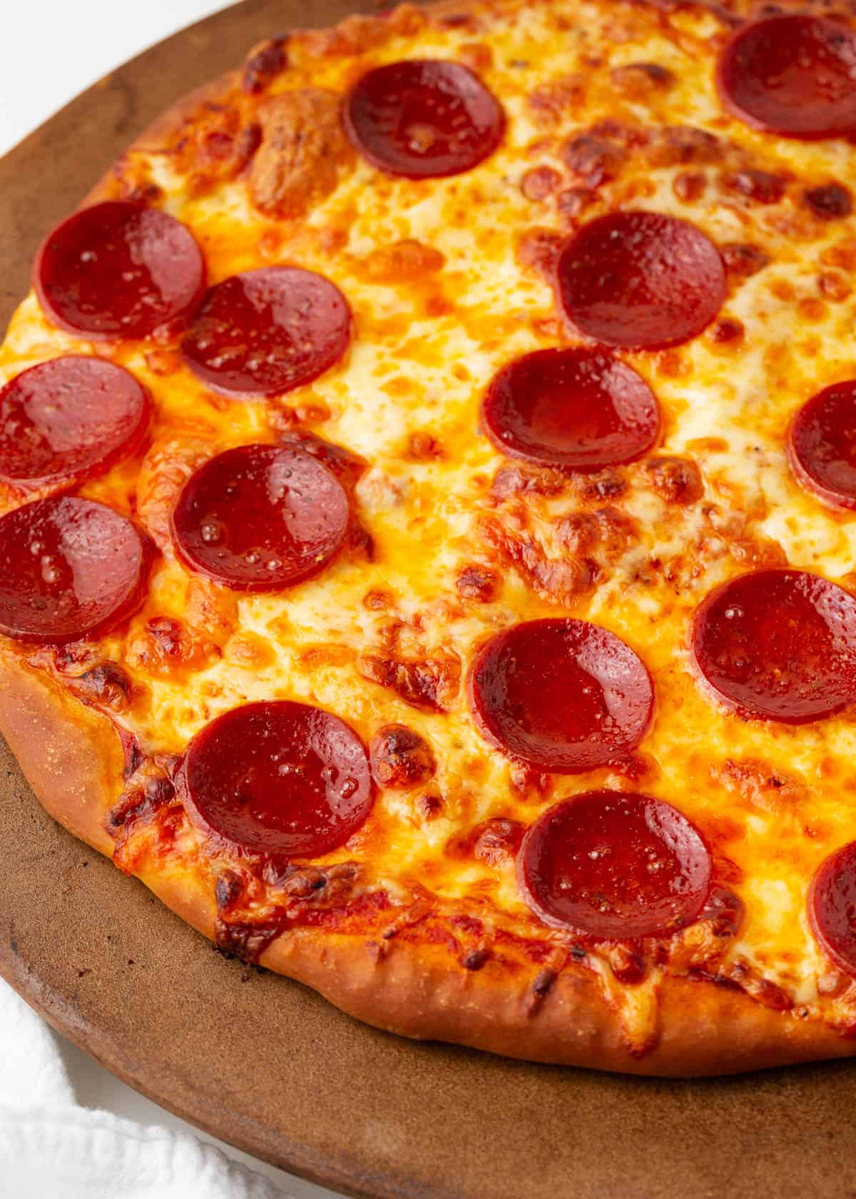 Pepperoni pizza on a pizza stone.
