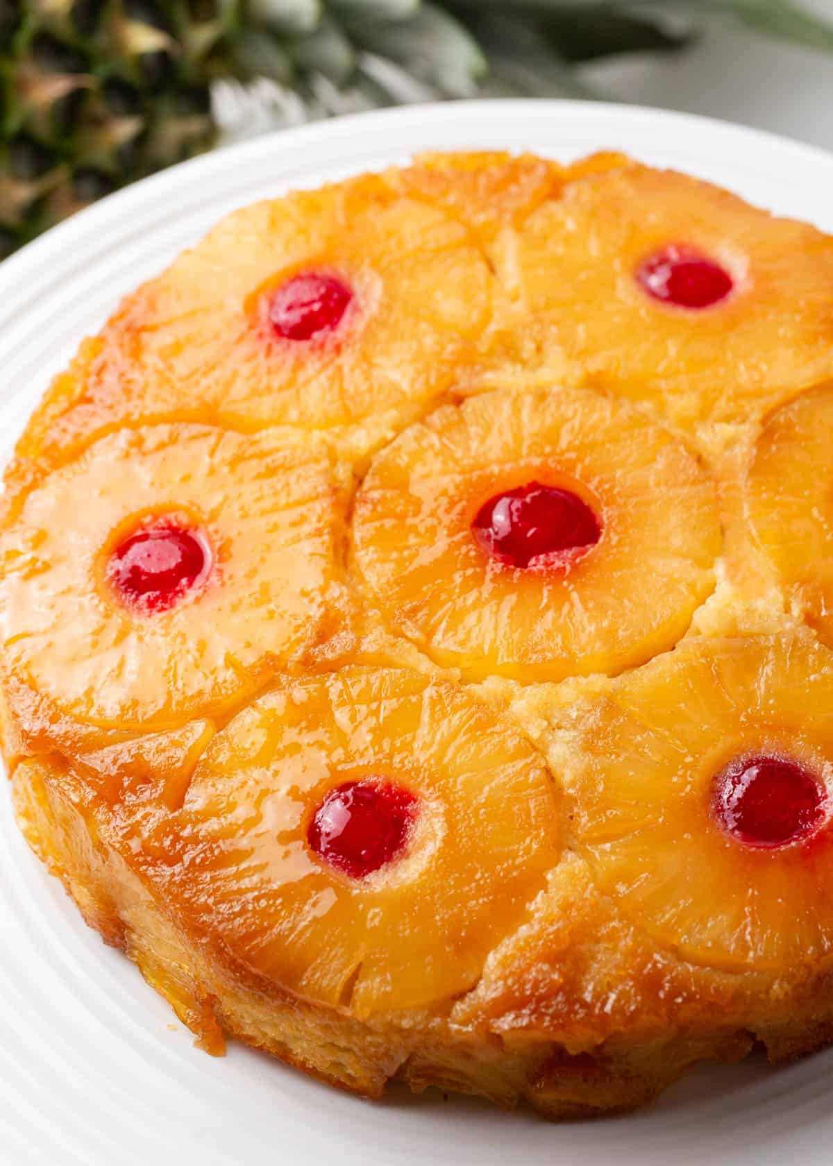 Pineapple upside down cake on white platter.