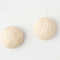Pizza dough balls on counter.