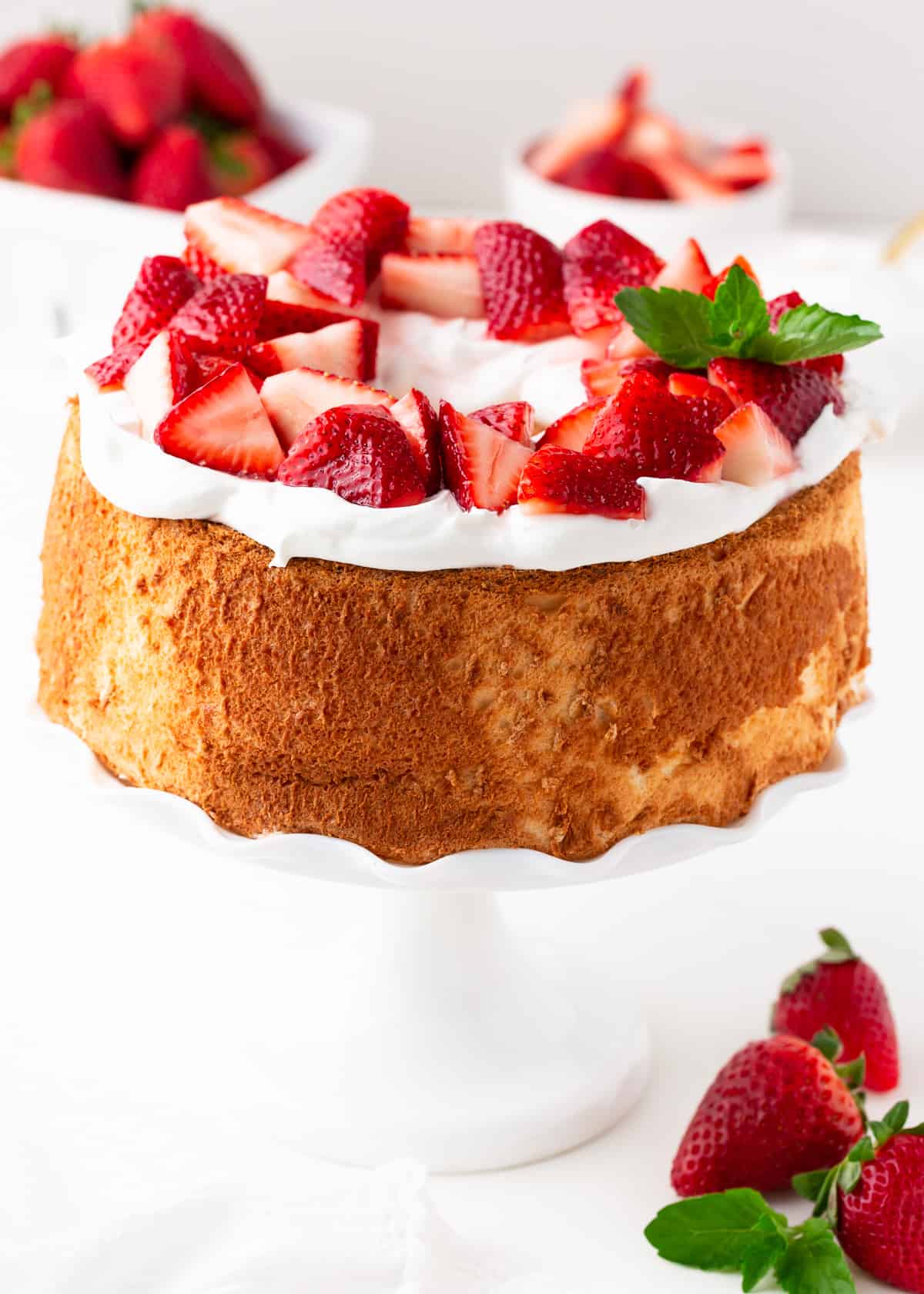 Strawberry shortcake on a white cake stand. 