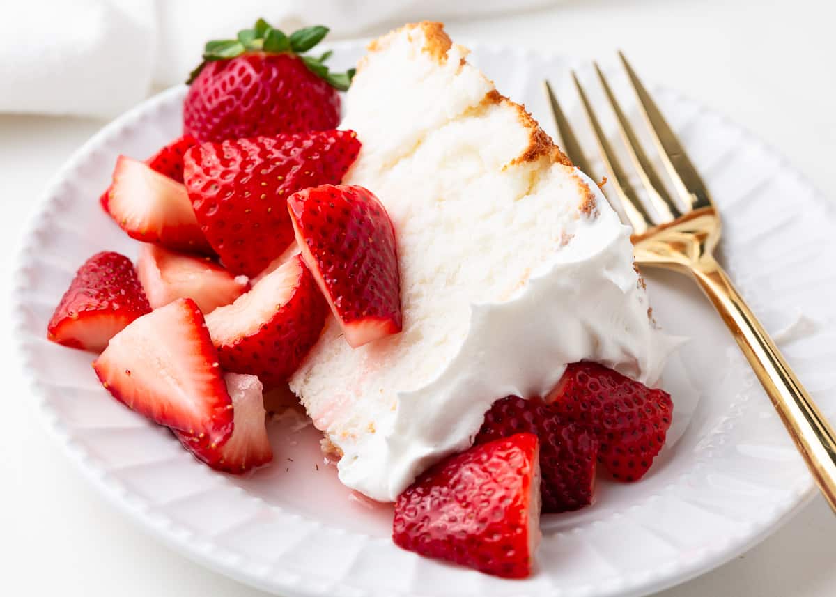 Slice of strawberry shortcake on a white plate.