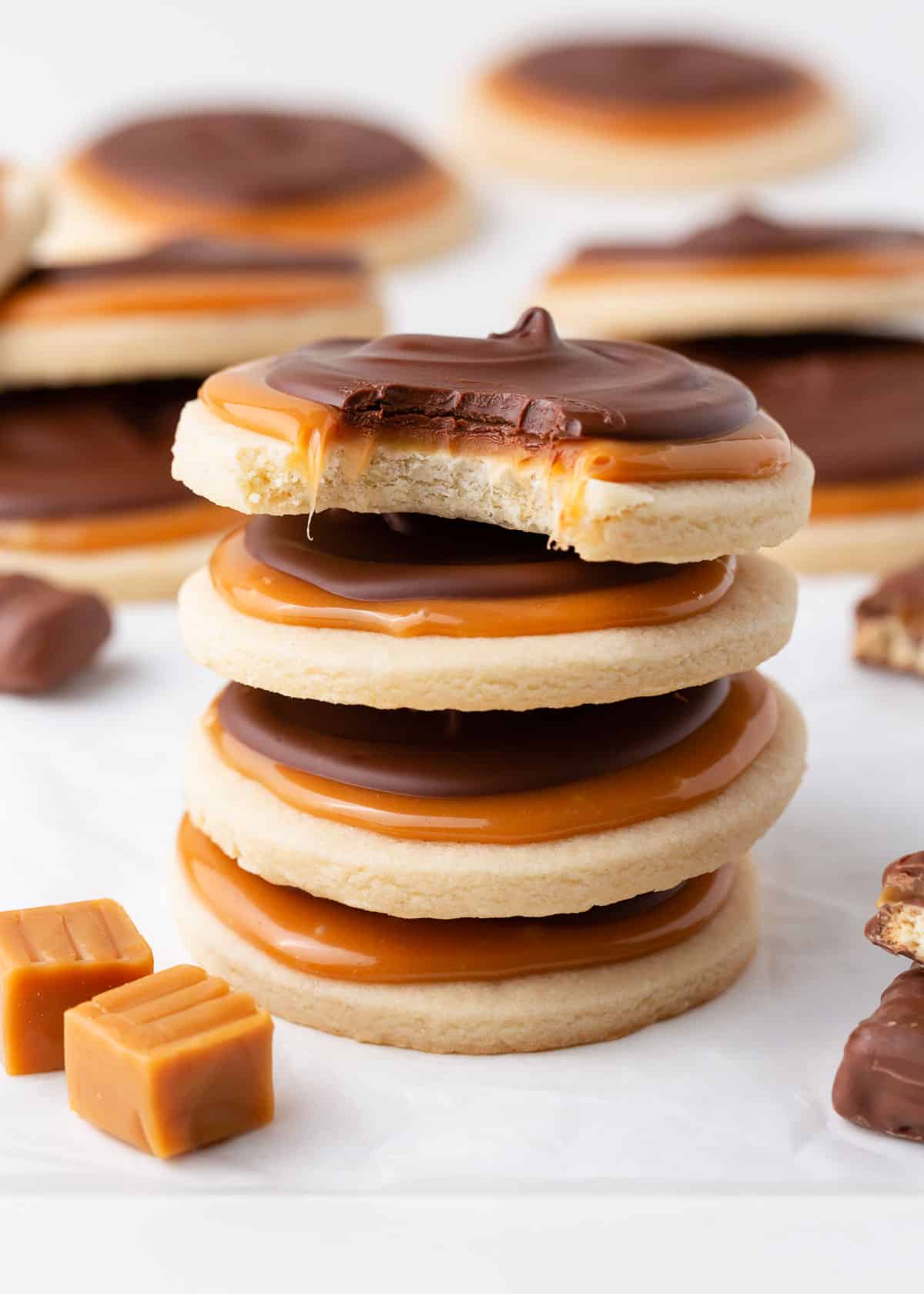 A stack of four twix cookies with caramel and chocolate.
