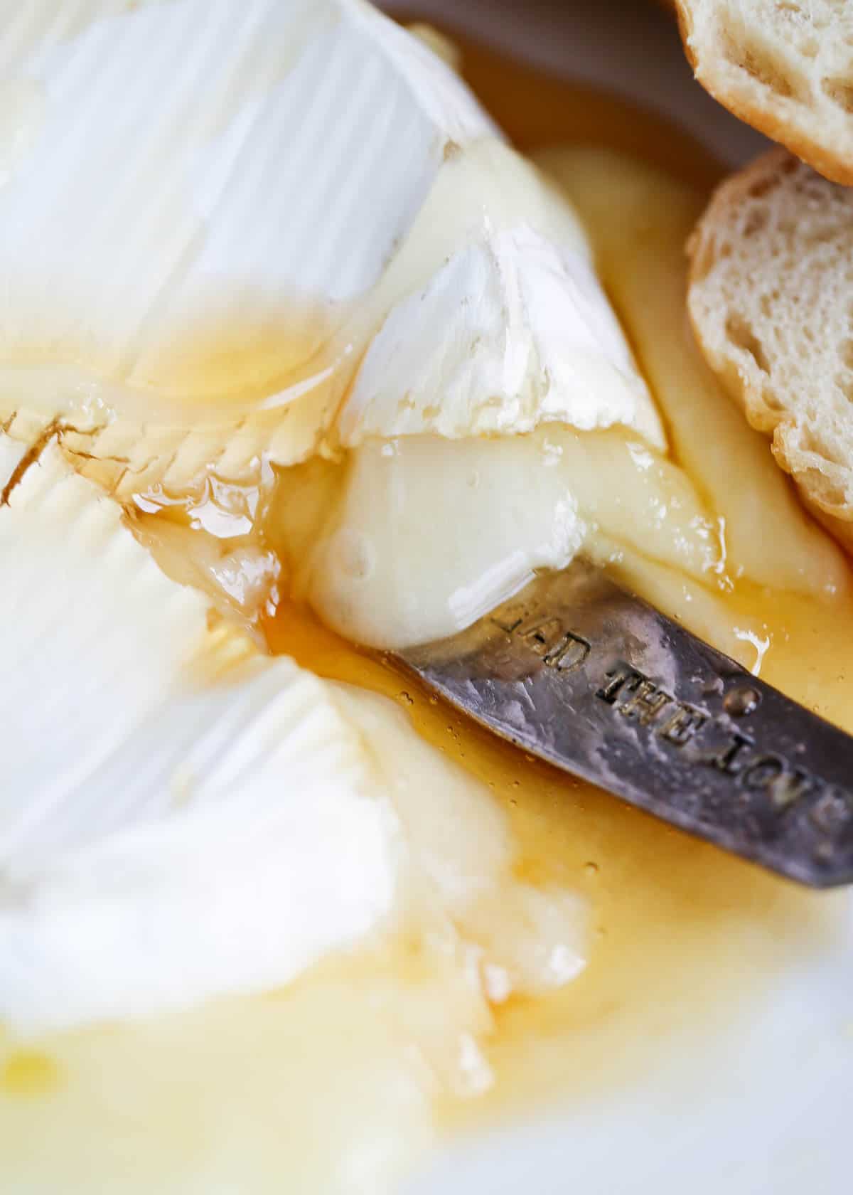 Baked brie with honey overtop with sliced bread 
