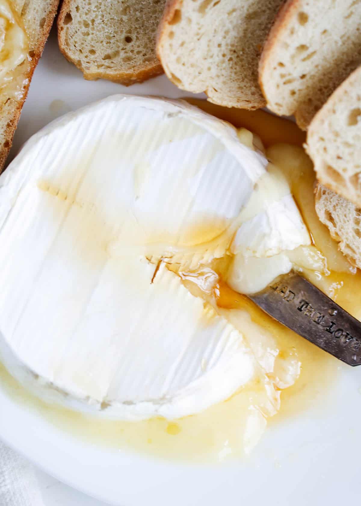 Over head photo of baked brie with slices of bread around. 