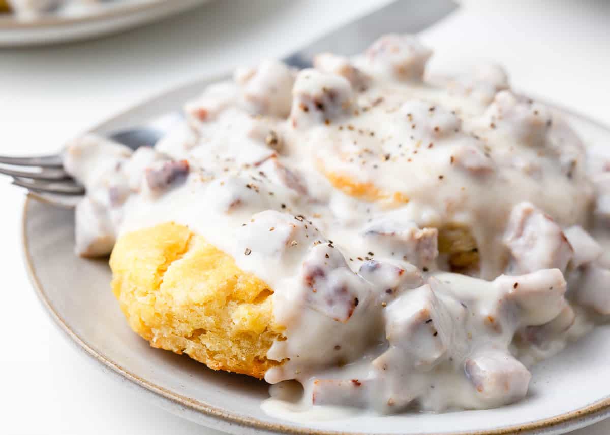 Biscuits and gravy on a plate with a fork.