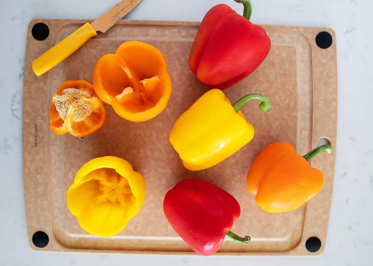 Bell peppers on a cutting board with a knife. 