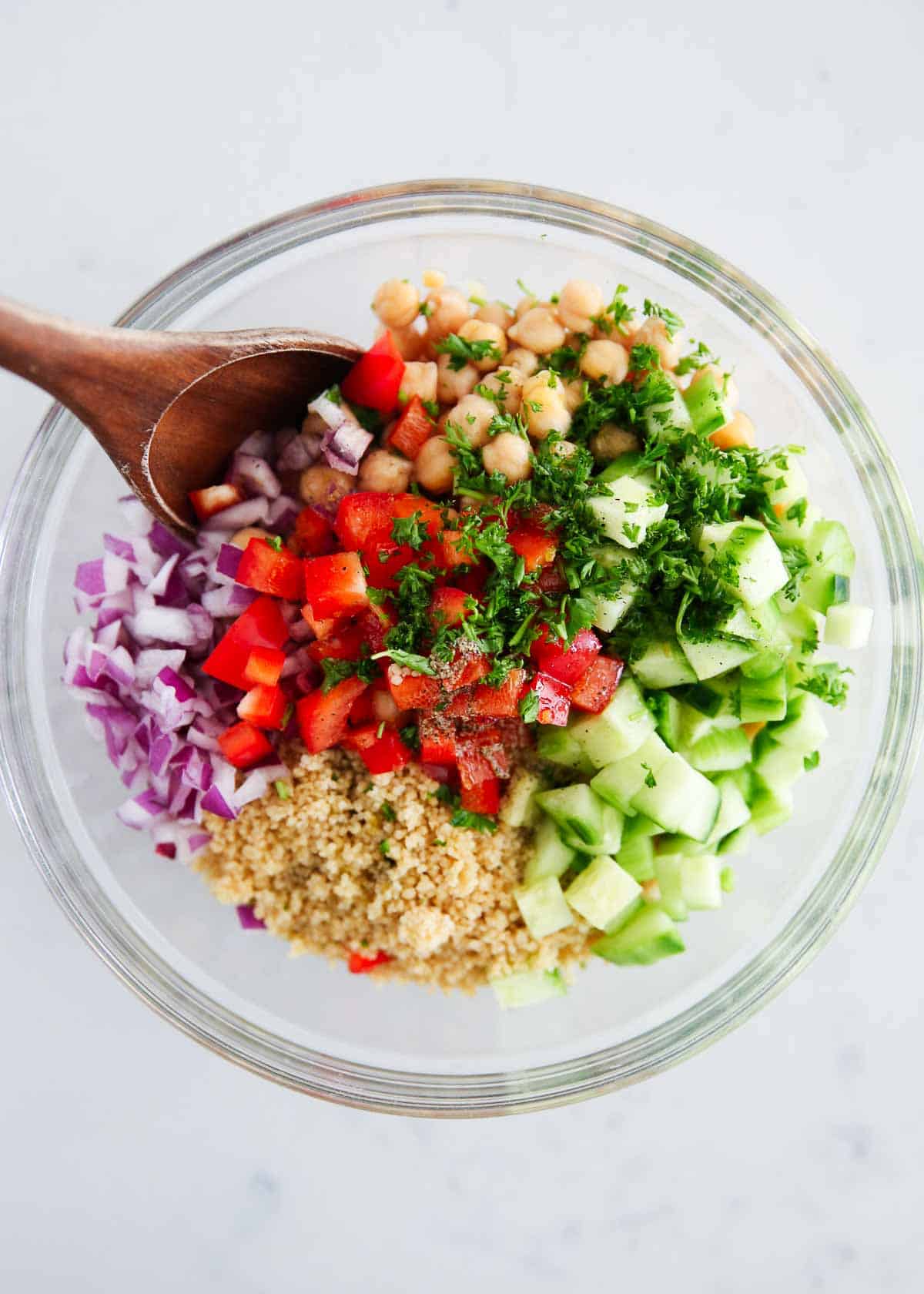 Showing how to make couscous salad in a glass bowl. 
