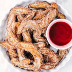 Homemade churros on a white plate.