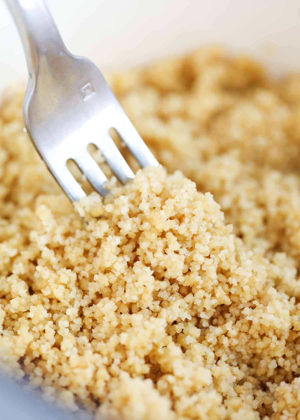 Fluffing couscous with a fork.