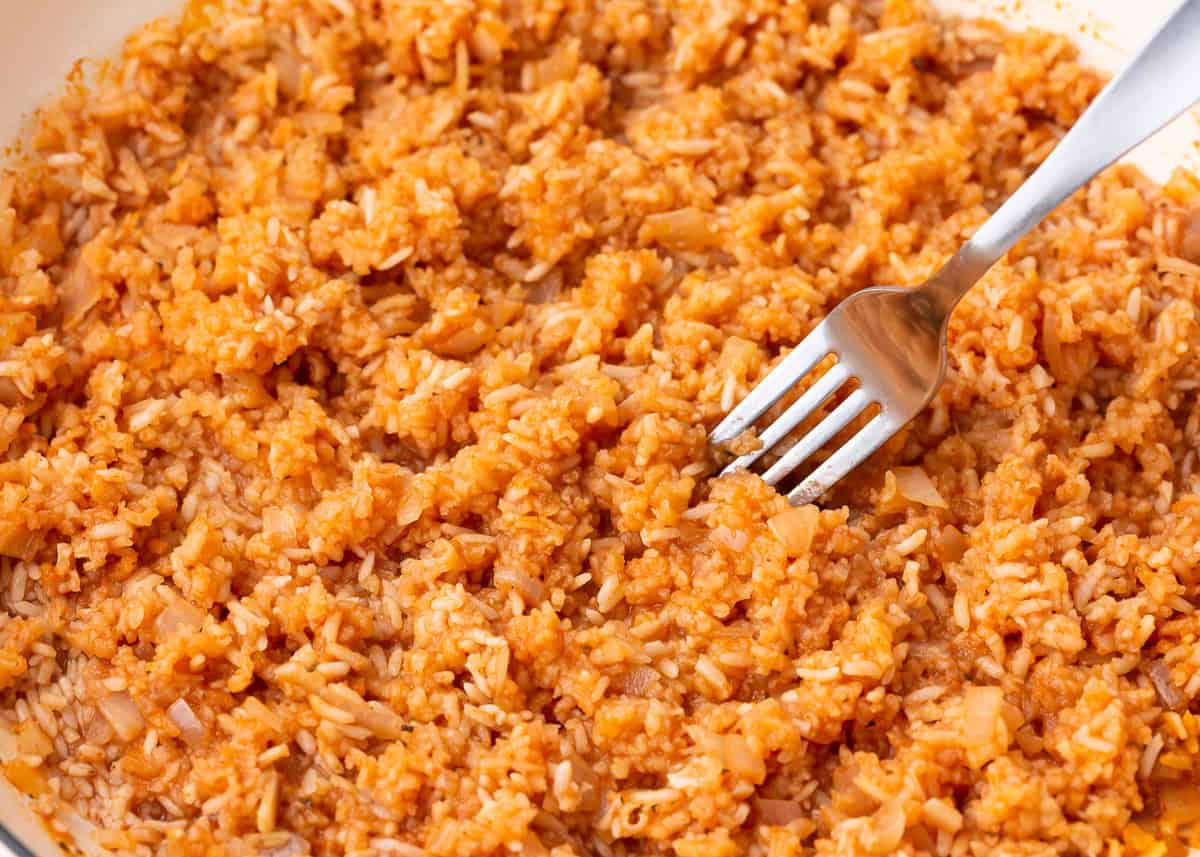 Fluffing Mexican rice with a fork.