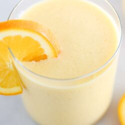 Orange Julius in a cup with orange slices.