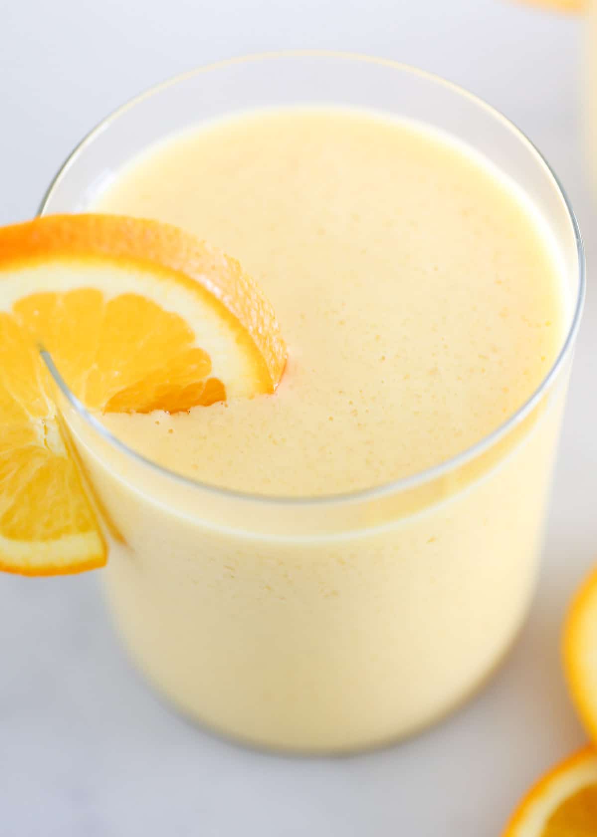 Orange Julius in a cup with orange slices.