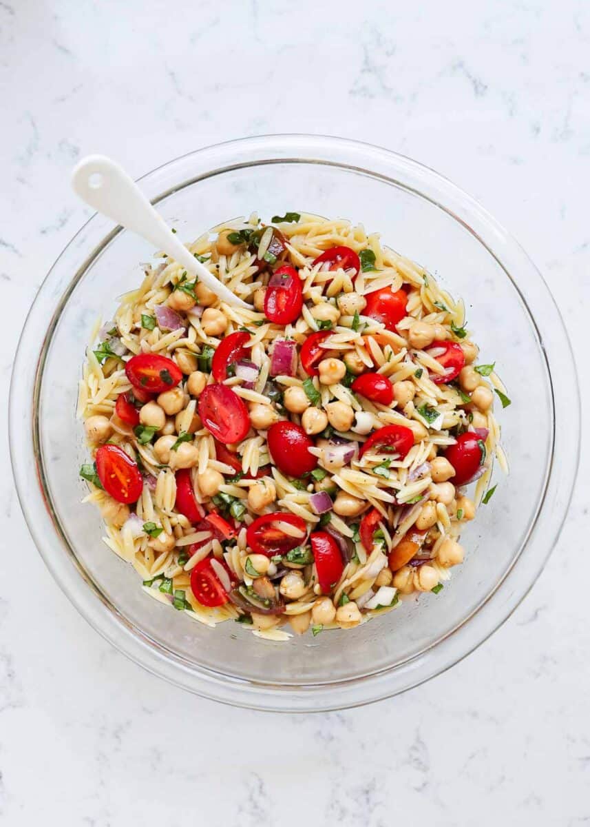 Orzo salad in a glass bowl.