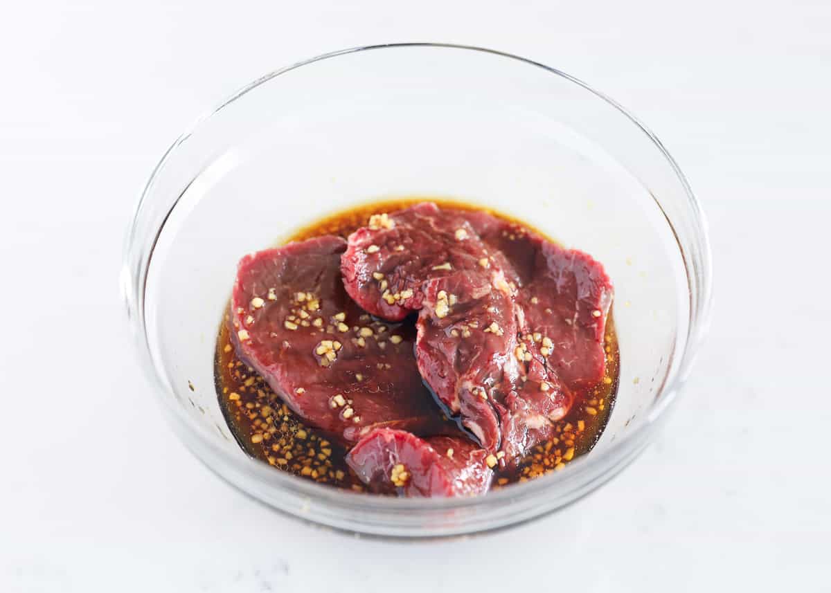 Steak marinading in a glass bowl. 