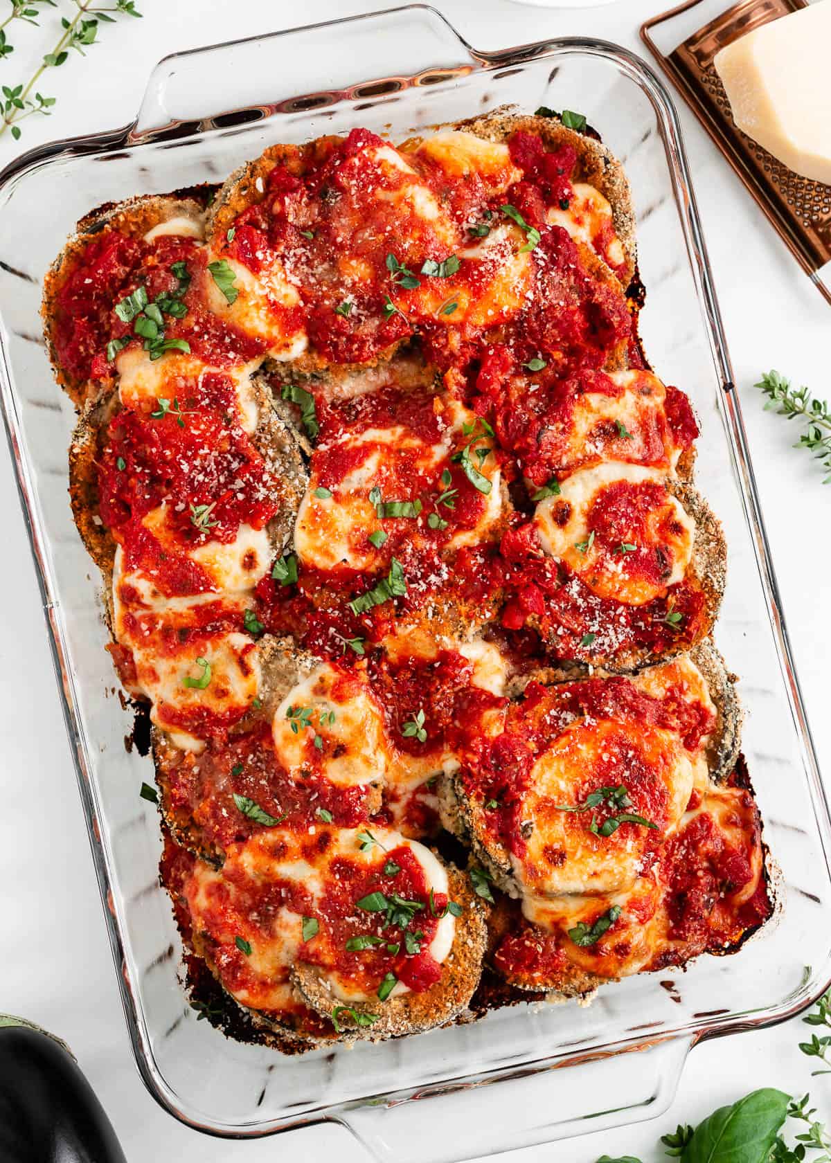 Eggplant parmesan baked in glass dish.