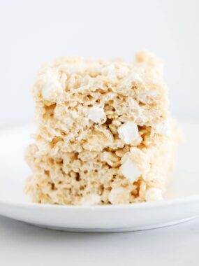 A stack of brown butter rice krispie treats on a white plate.