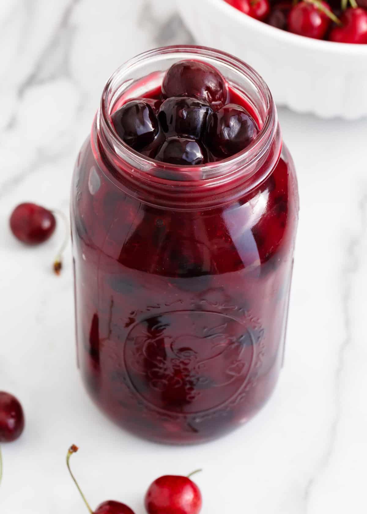 Cherry pie filling in a glass jar.