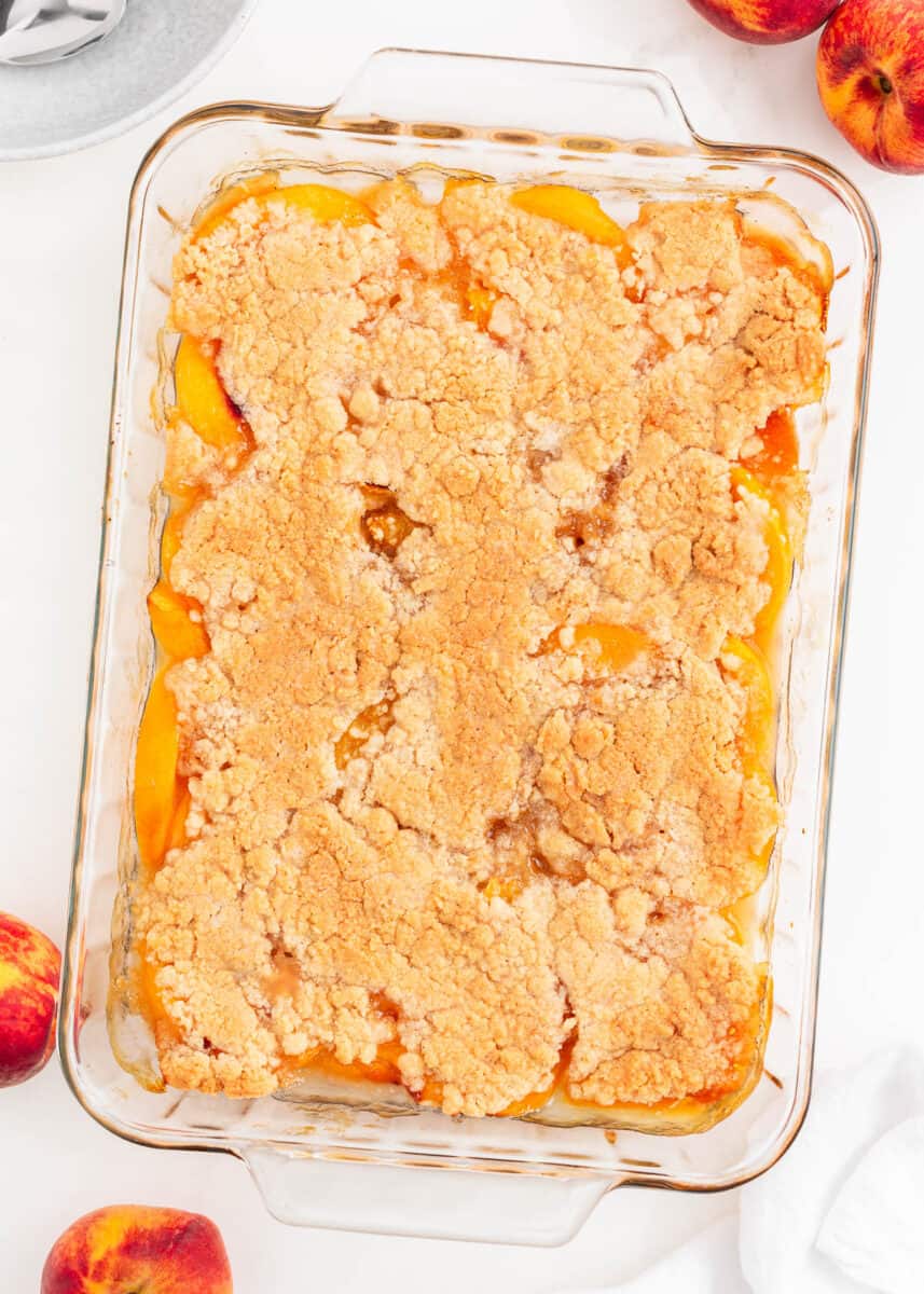 Peach cobbler baked in a glass dish.