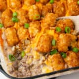 Easy tater tot casserole in a glass dish with spoon.