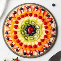 Assembled fruit pizza on counter.