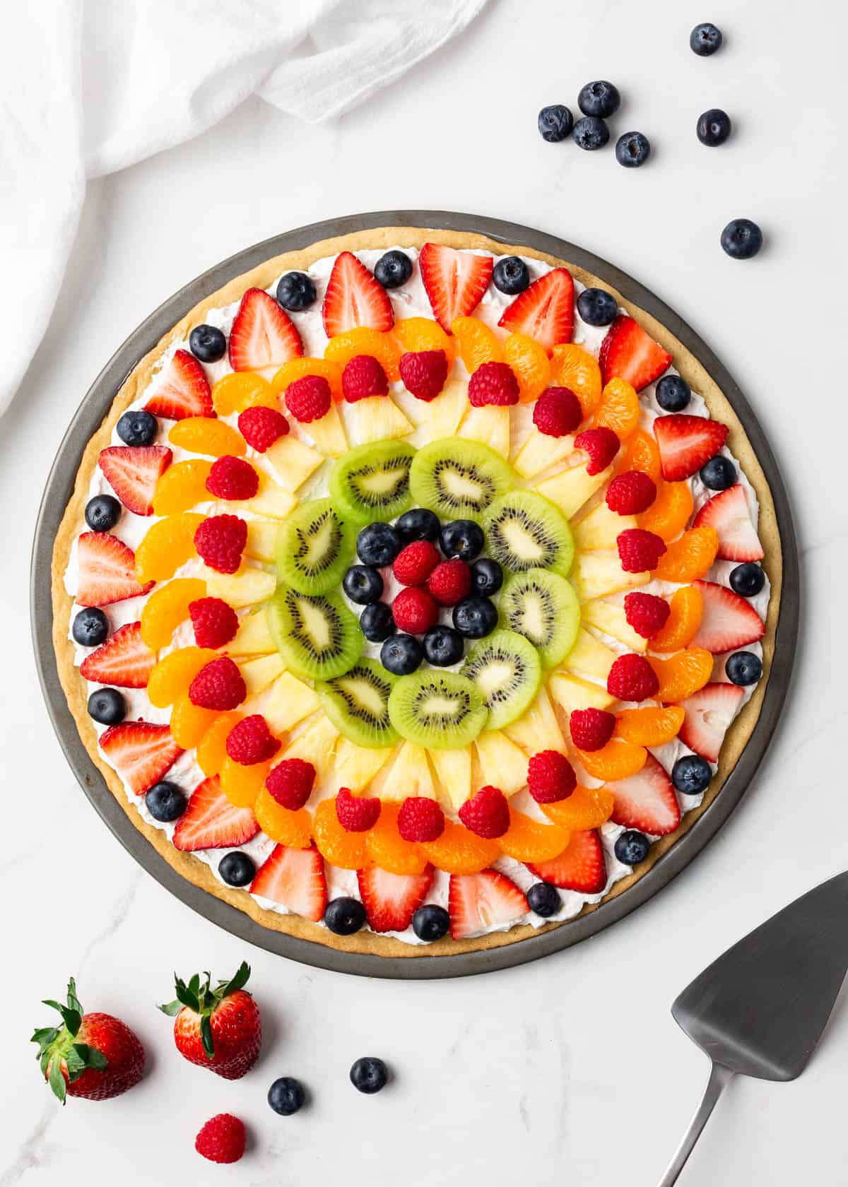 Assembled fruit pizza on counter.