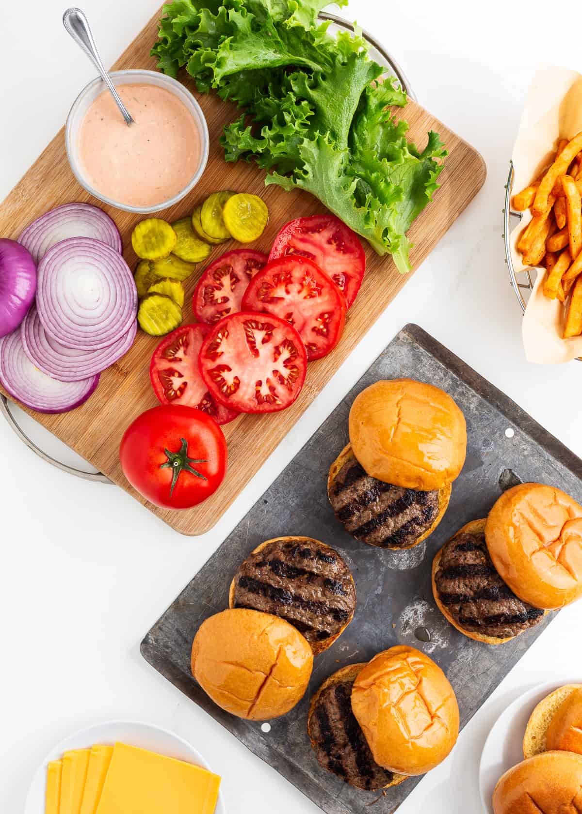 Hamburgers and toppings on counter.