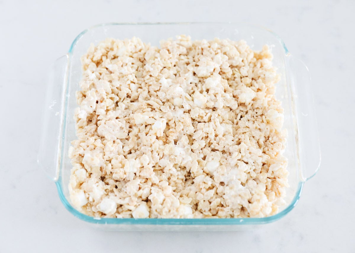 These brown butter rice krispie treats are like the classic but with a small updated twist! Brown butter gives the sticky, gooey treats a delicious nuttiness that is irresistible. Brown butter rice krispie treats in a clear baking dish.